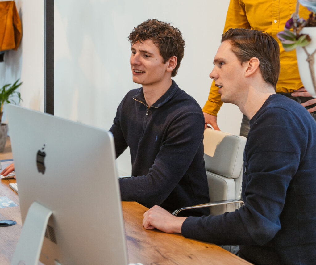 Functioneel beheer twee simplex medewerkers die naar computerscherm kijken